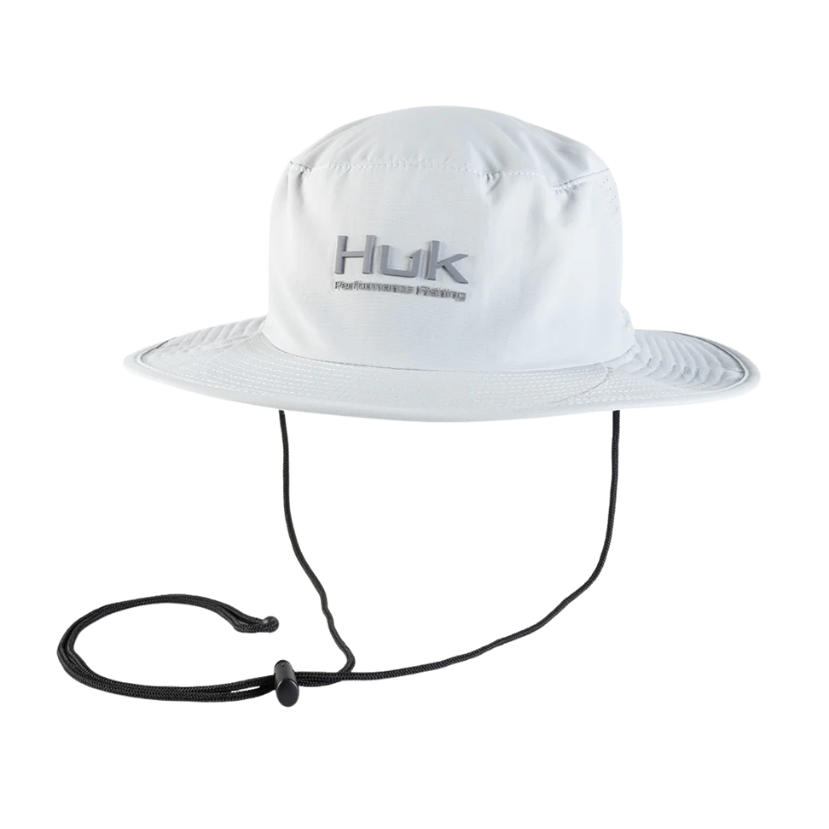White fishing boonie hat with a strap on a white background, featuring the Huk brand.