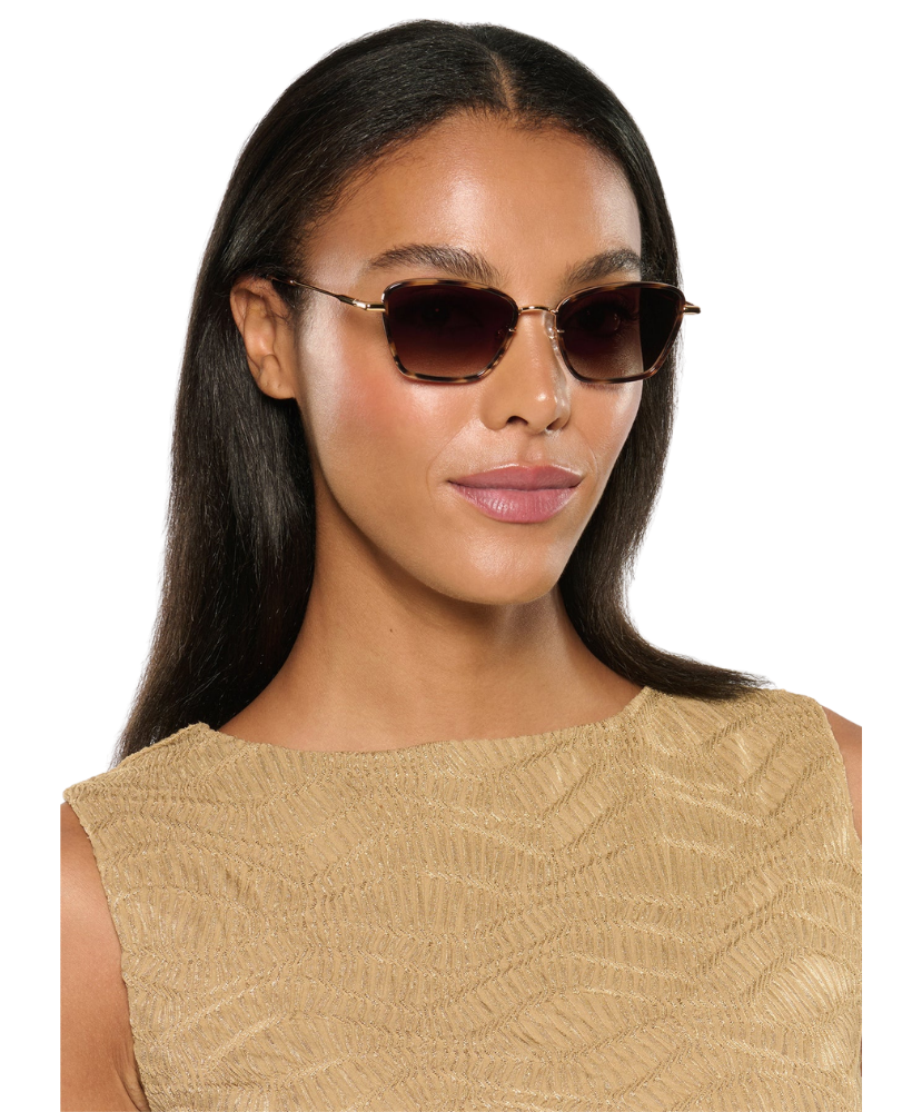Woman wearing Krewe sunglasses with a plain background