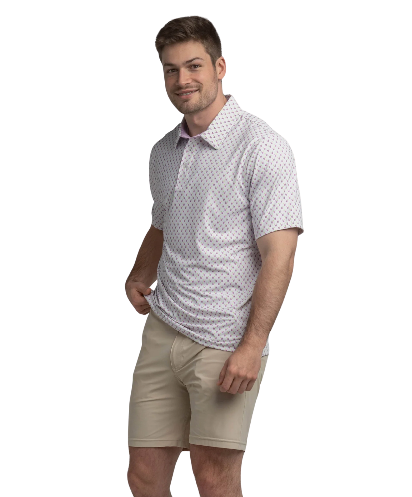 Man wearing a transfusion patterned Southern Shirt Co polo shirt and beige shorts on a white background