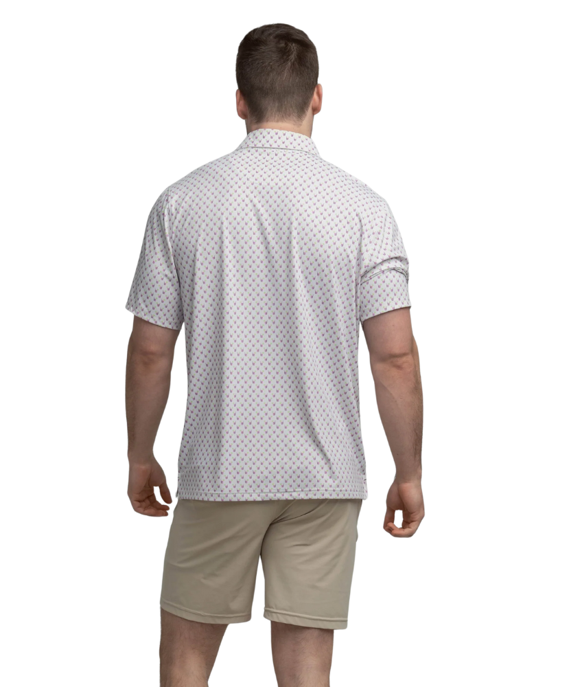 Man wearing a transfusion patterned Southern Shirt Co polo shirt and beige shorts on a white background