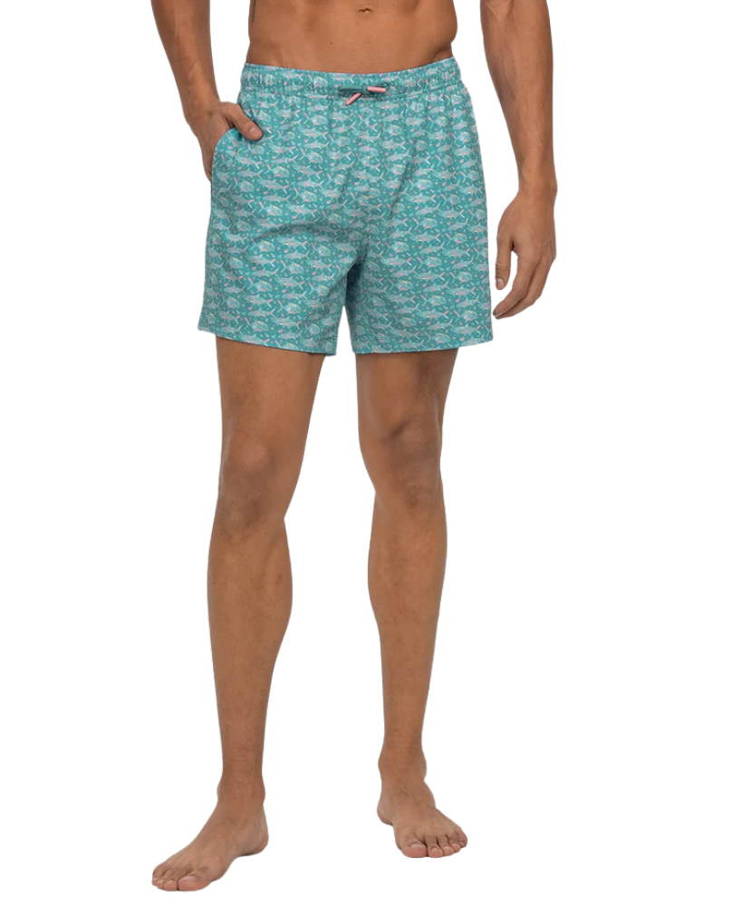 Person wearing teal patterned swim shorts on a white background