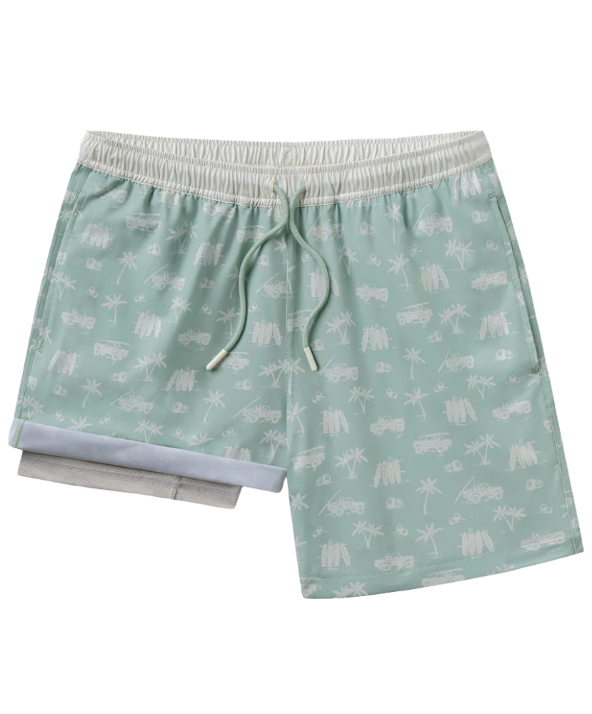 Green swim shorts with white coastal patterns on a white background