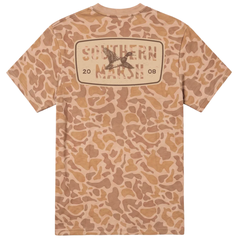 A short-sleeve t-shirt with a tan and brown camouflage pattern, featuring a large graphic on the back with the text 'SOUTHERN MARSH' and a duck hunter logo.