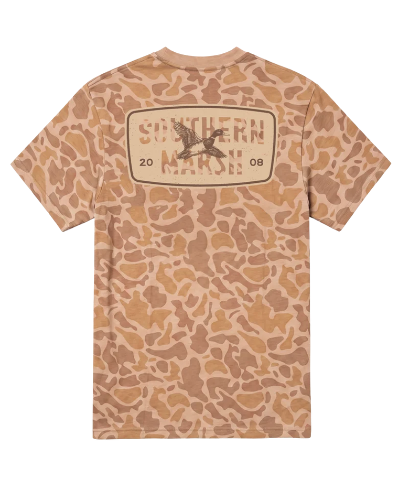 A short-sleeve t-shirt with a tan and brown camouflage pattern, featuring a large graphic on the back with the text 'SOUTHERN MARSH' and a duck hunter logo.