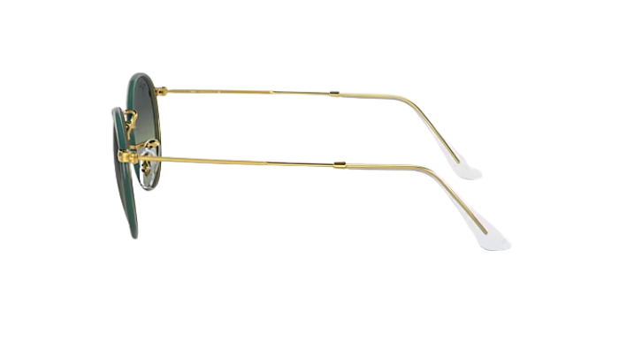 Sunglasses with gold frame and green lenses on a white background
