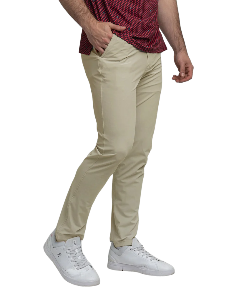 Person wearing beige pants and white sneakers on a white background