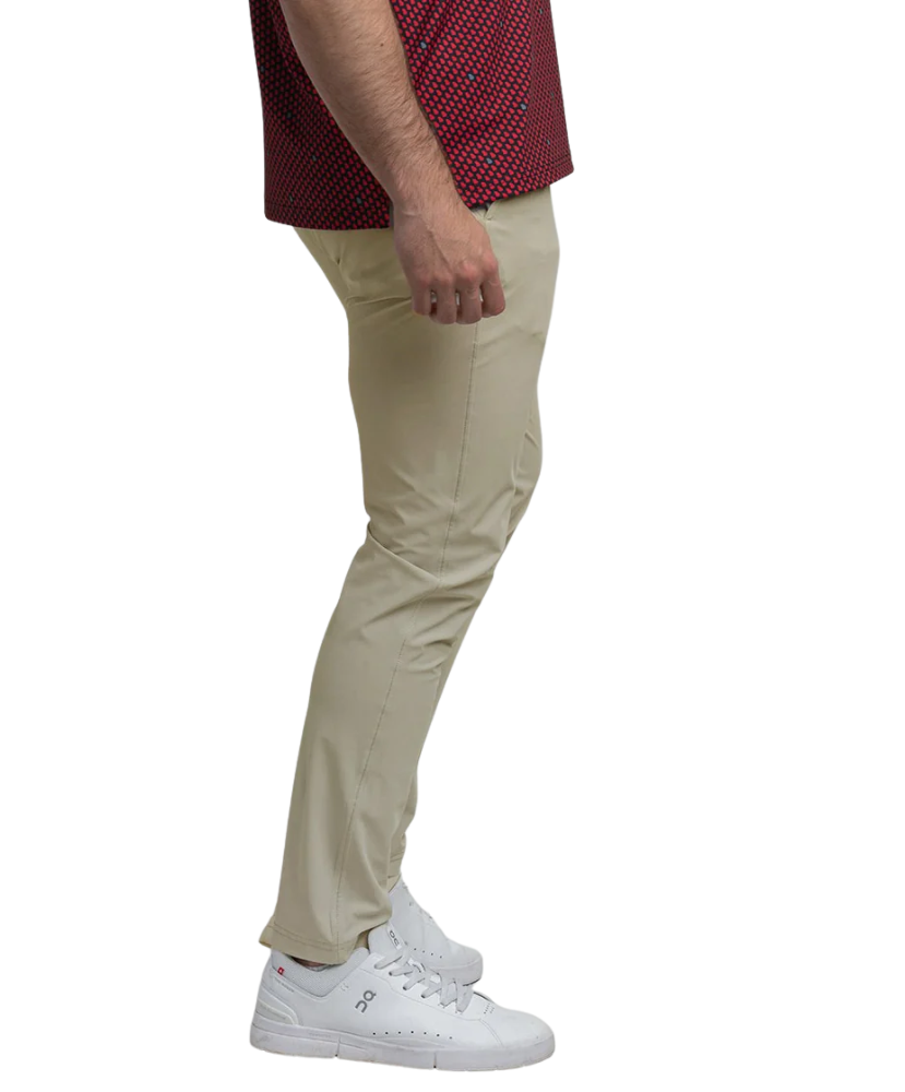 Person wearing beige pants and white sneakers on a white background