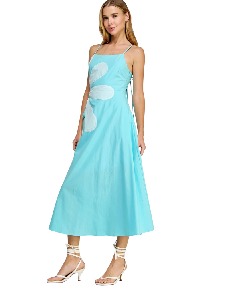 Woman wearing a light blue dress with floral patterns on a white background