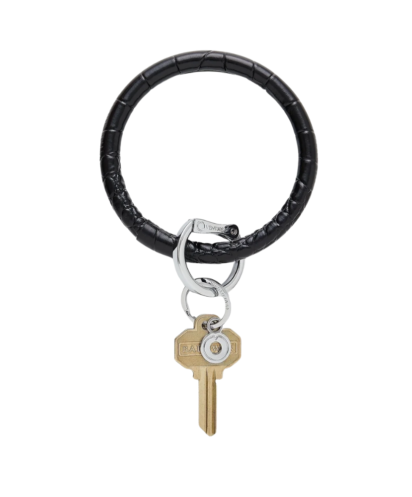 Black leather keychain with a gold key on a white background