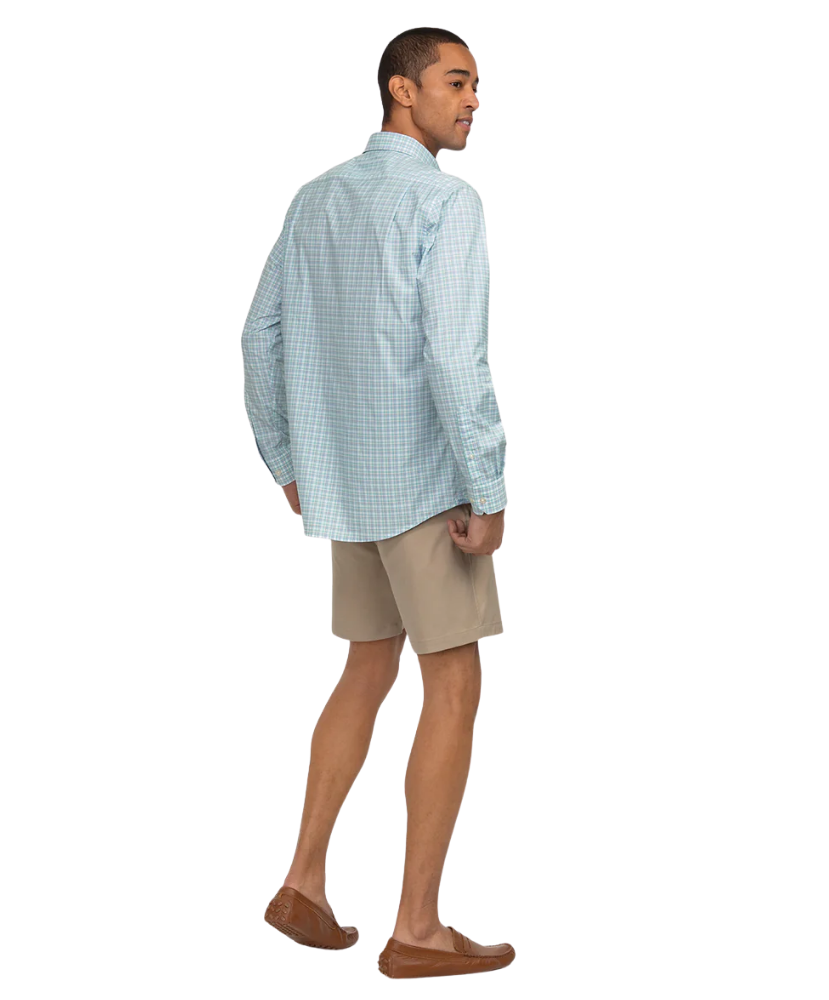 Man wearing a light blue checkered shirt and beige shorts on a white background