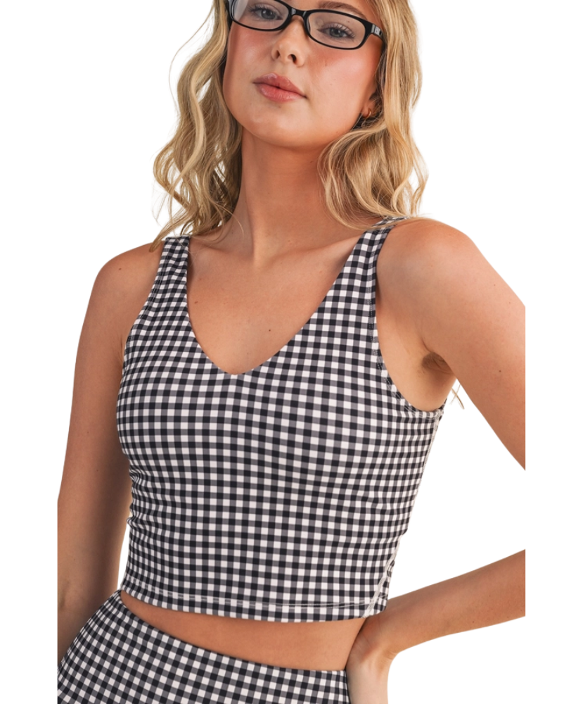 Woman wearing a black and white GINGHAM checkered tank on a white background