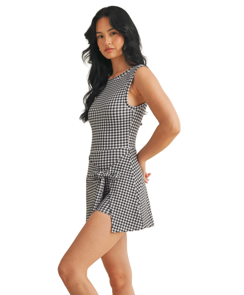 Woman wearing a black and white gingham checkered dress on a white background