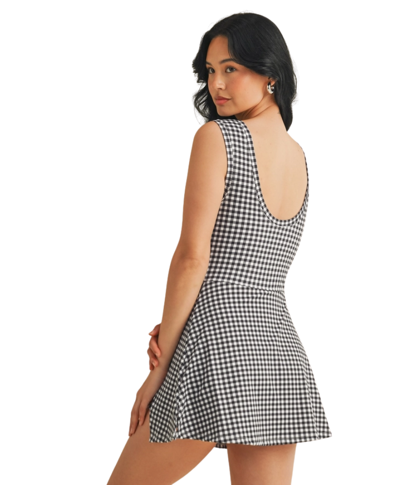 Woman wearing a black and white gingham checkered dress on a white background