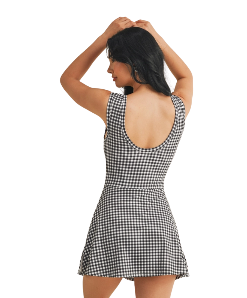 Woman wearing a black and white gingham checkered dress on a white background