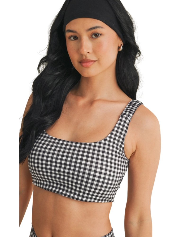 Woman wearing a black and white GINGHAM checkered tsports bra on a white backgrounD