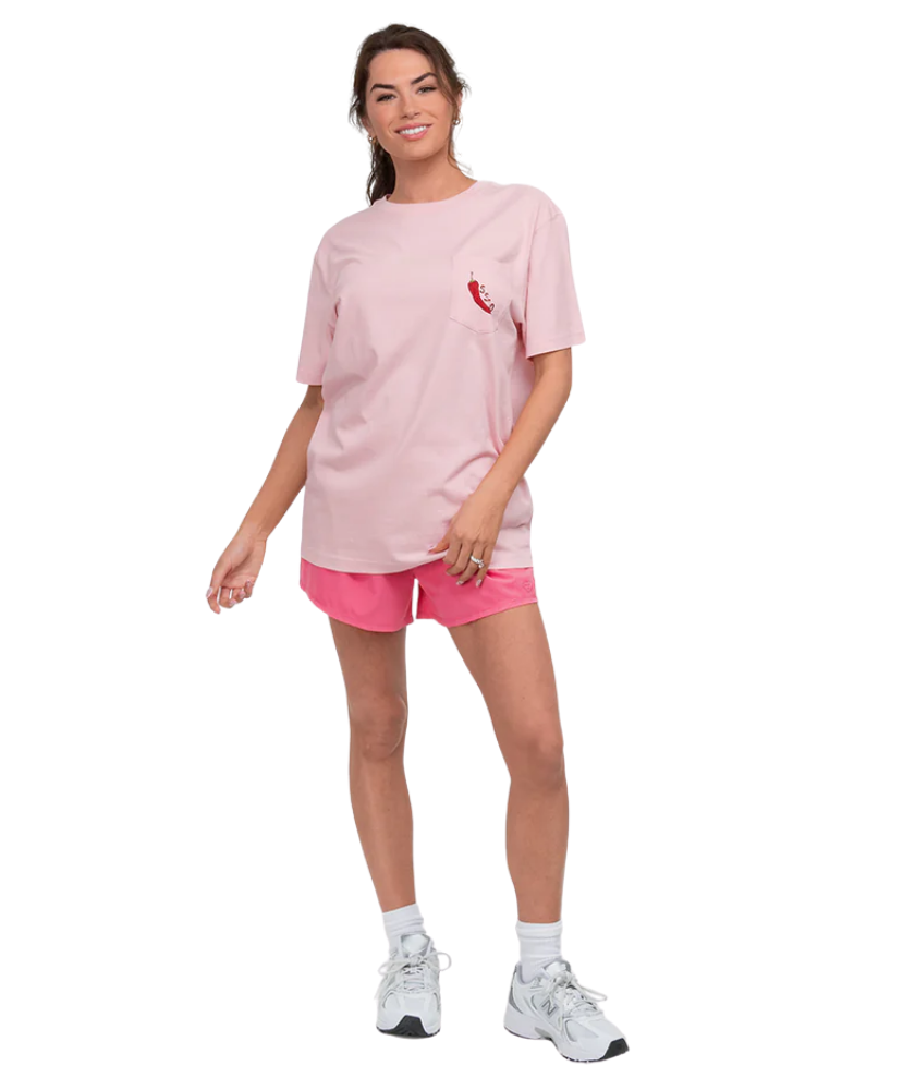 Woman wearing a pink Southern Shirt Co t-shirt and shorts set on a white background