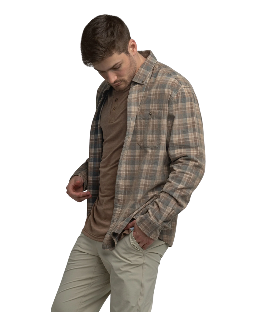 Man wearing a flannel plaid shirt over a brown shirt on a white background