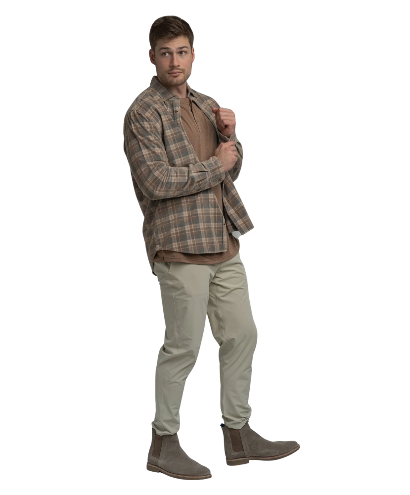 Man wearing a plaid flannel shirt, brown shirt, beige pants, and brown boots on a white background