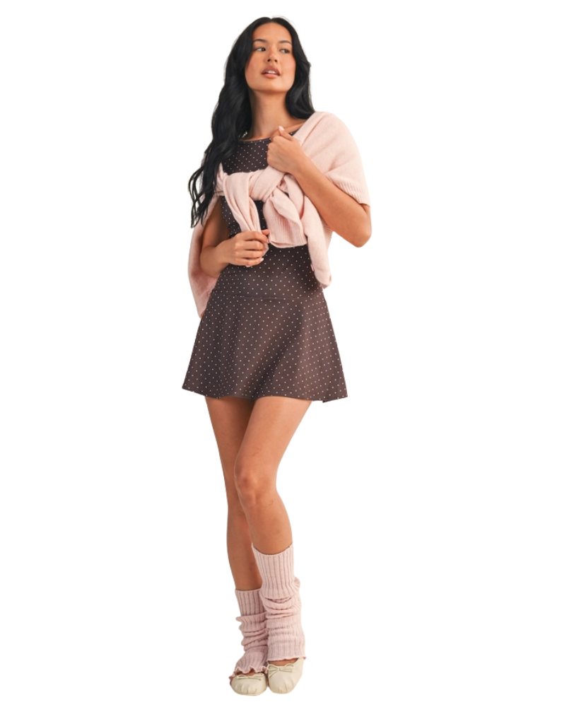 Woman wearing a brown polka dot dress on a white background