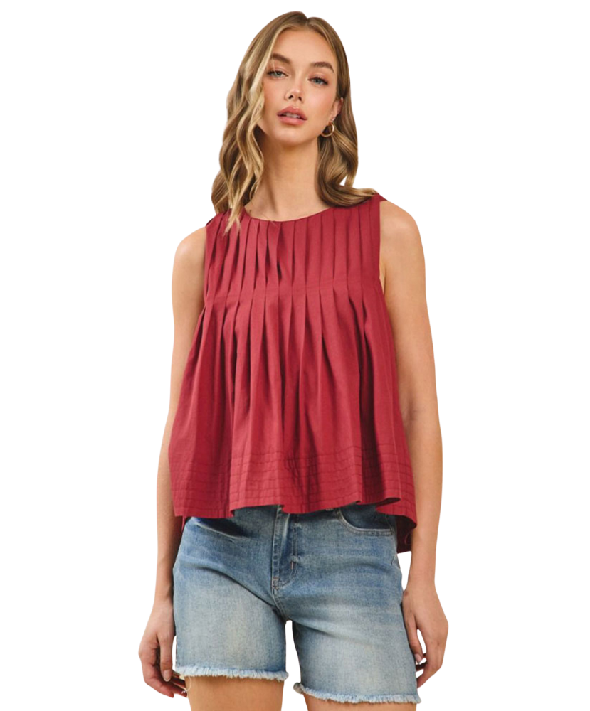 Woman wearing a burgundy sleeveless top and denim shorts on a white background