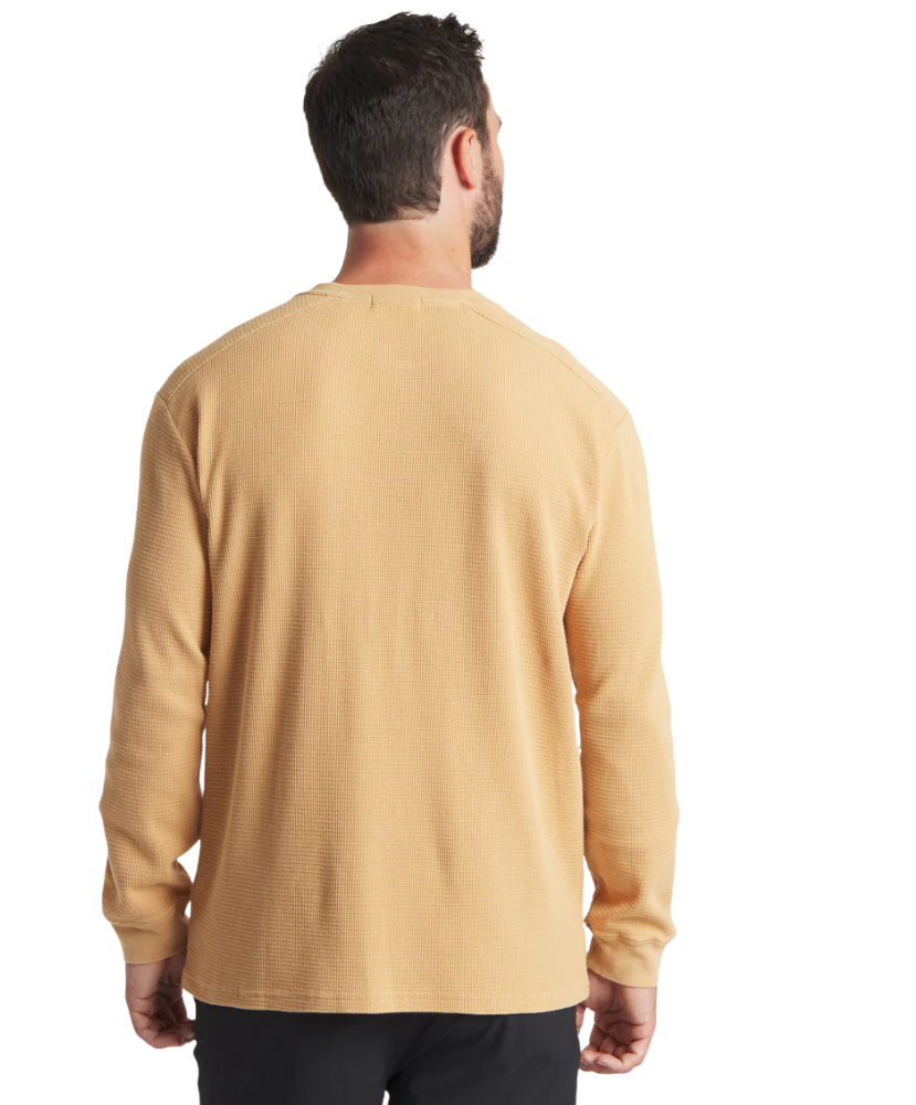 Man wearing a beige long-sleeve henley shirt on a white background