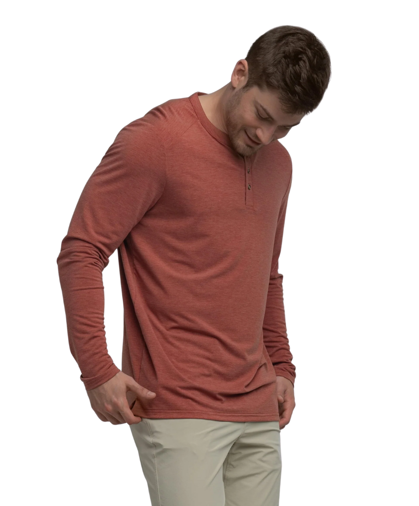 Man wearing a red long-sleeve henley shirt and beige pants on a white background