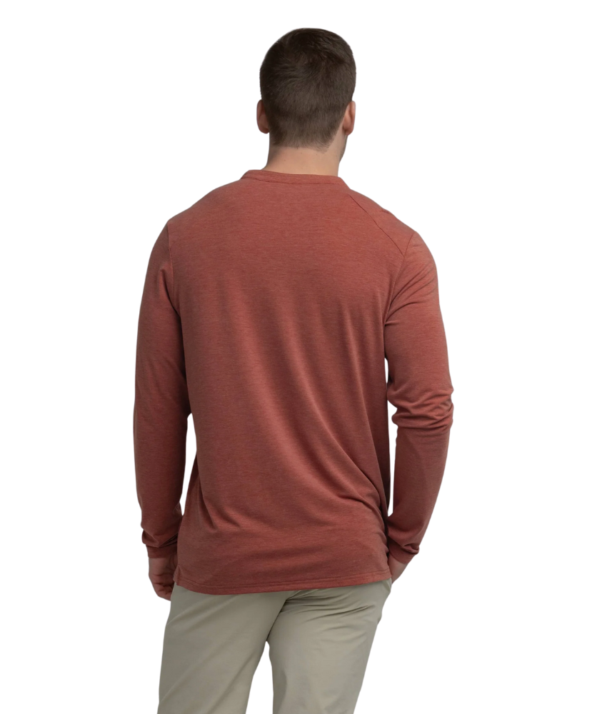 Man wearing a rust-colored long-sleeve henley shirt on a white background