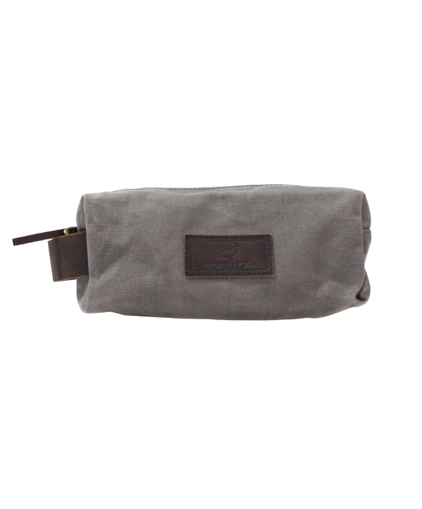 Gray toiletry bag with brown leather patch on a white background