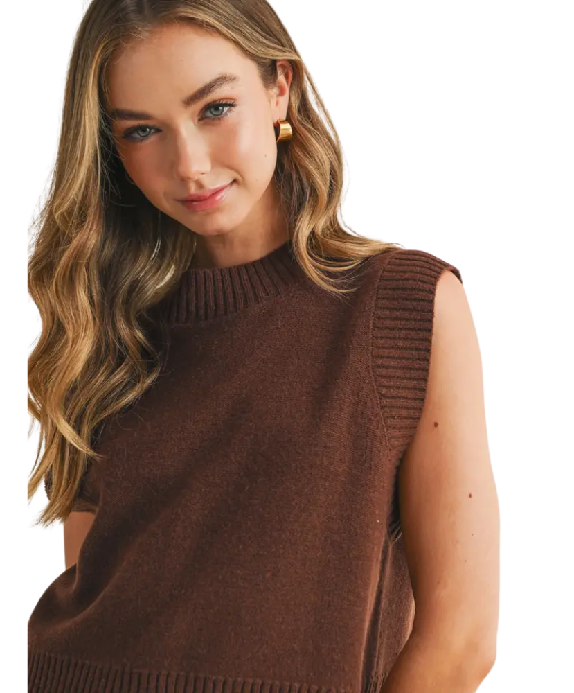 Woman wearing a brown sleeveless sweater on a white background