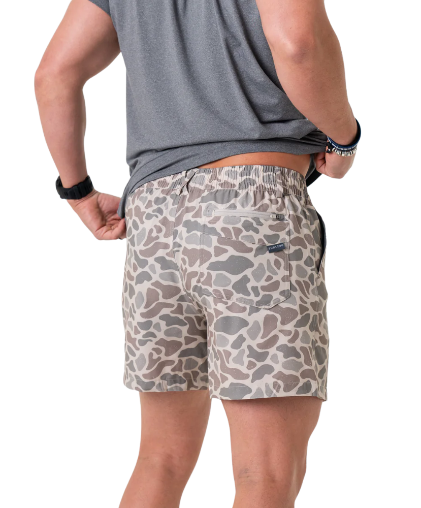 Person wearing camouflage shorts on a white background