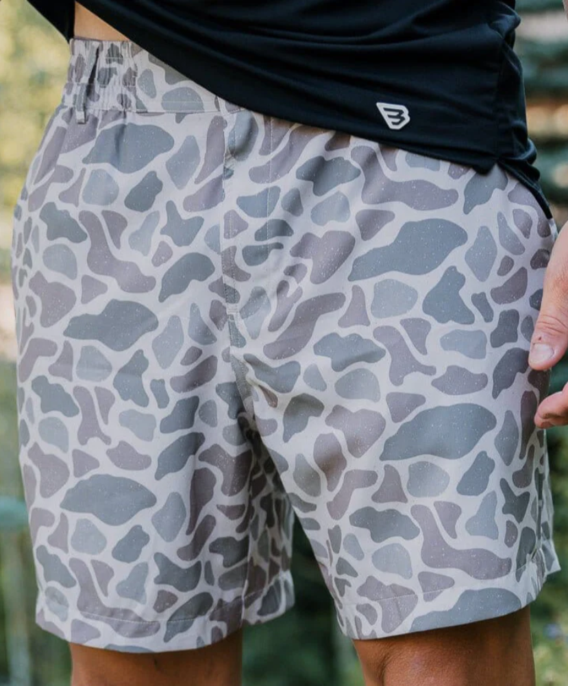 Person wearing camouflage shorts with a blurred background