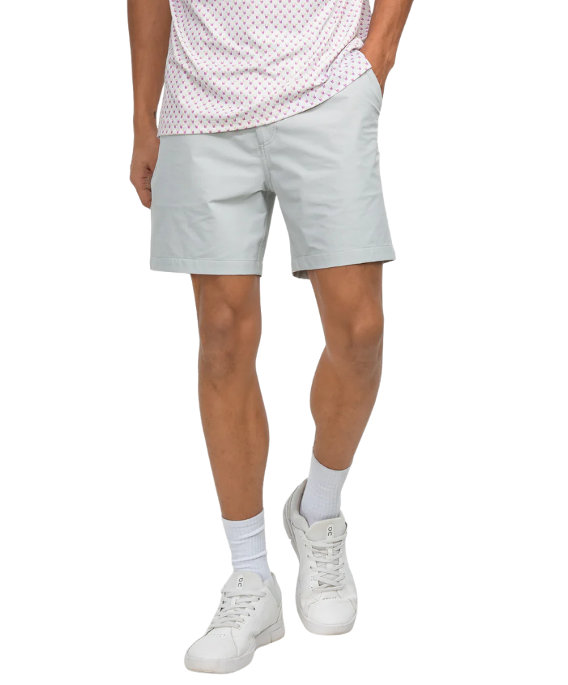 Person wearing light gray shorts, white sneakers, and a patterned shirt on a white background