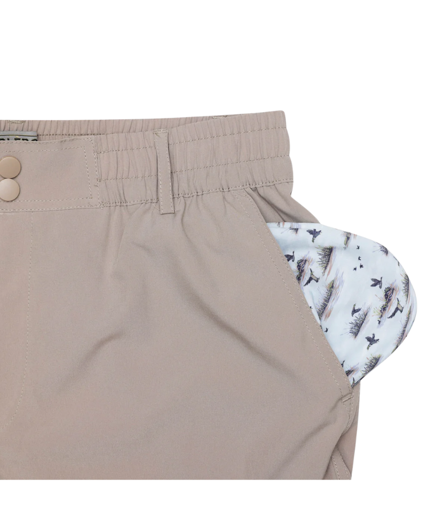 Close-up of khaki pants with a patterned lining on a white background