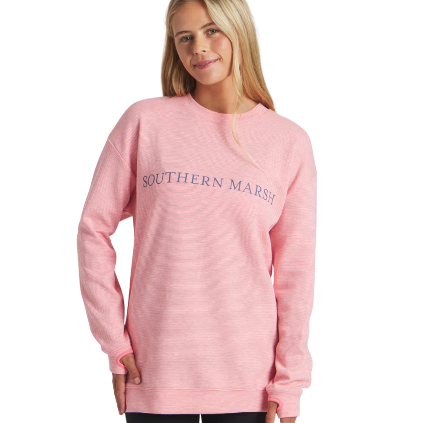 Woman wearing a pink sweatshirt with 'Southern Marsh' logo on a white background