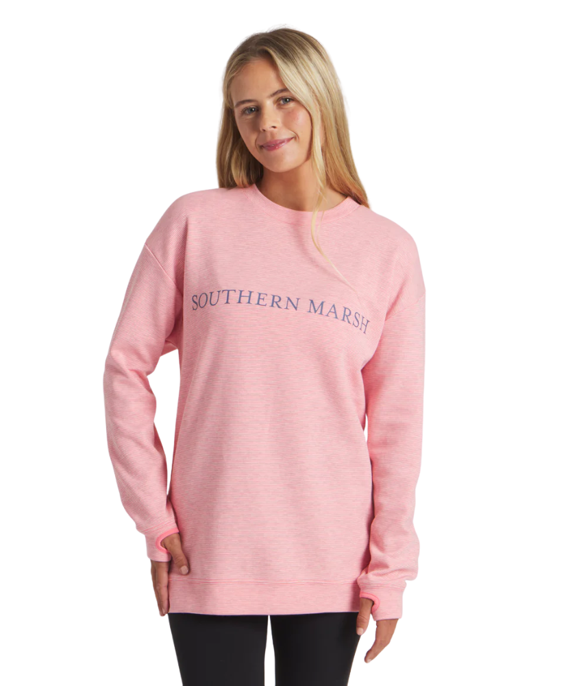 Woman wearing a pink sweatshirt with 'Southern Marsh' logo on a white background