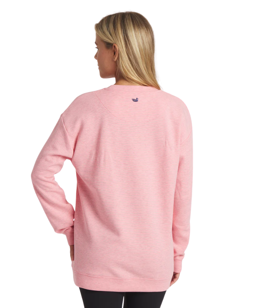 Person wearing a pink long-sleeve shirt with a brand logo on the back against a white background