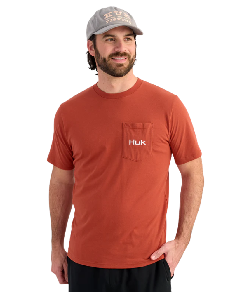Man wearing a red Huk t-shirt and cap on a white background