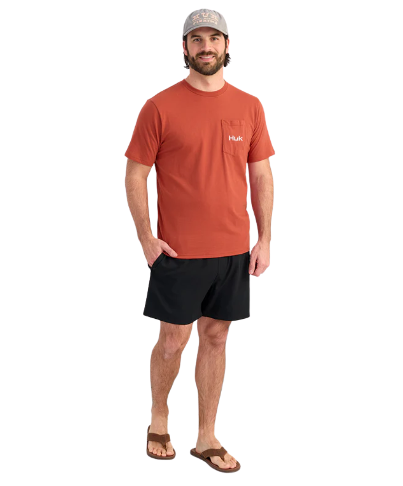 Man wearing an red huk t-shirt and black shorts on a white background