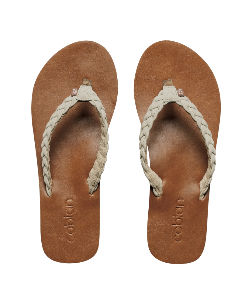 Pair of tan sandals with braided straps on a white background