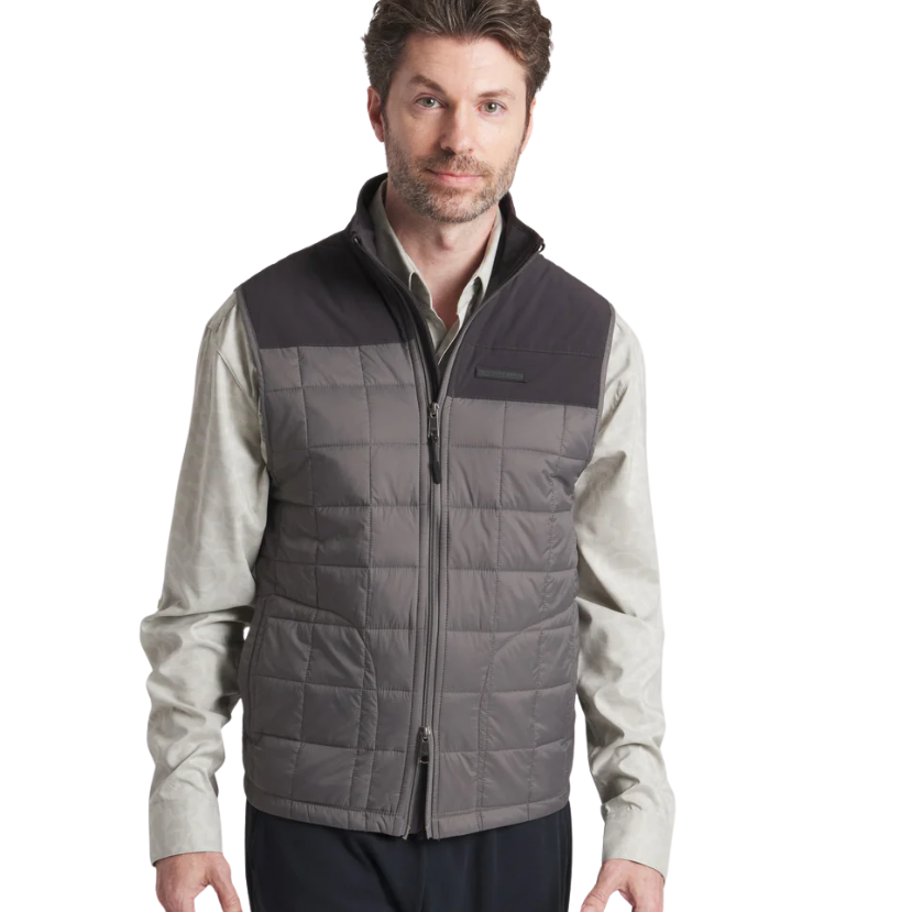 Man wearing a gray quilted vest over a light shirt on a white background
