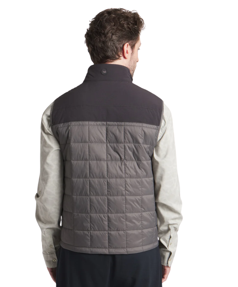 Man wearing a two-tone jacket with a quilted gray back on a white background
