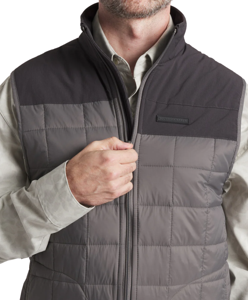 Gray quilted vest with black accents worn by a person on a white background