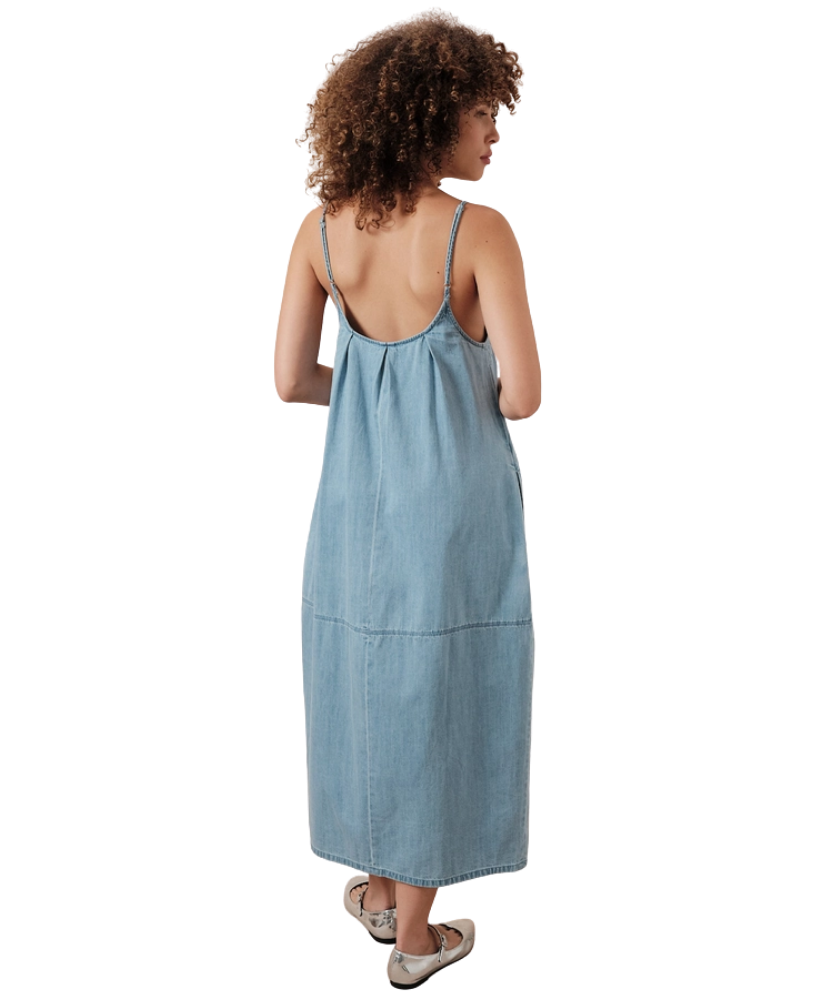 Woman wearing a light blue denim dress on a white background