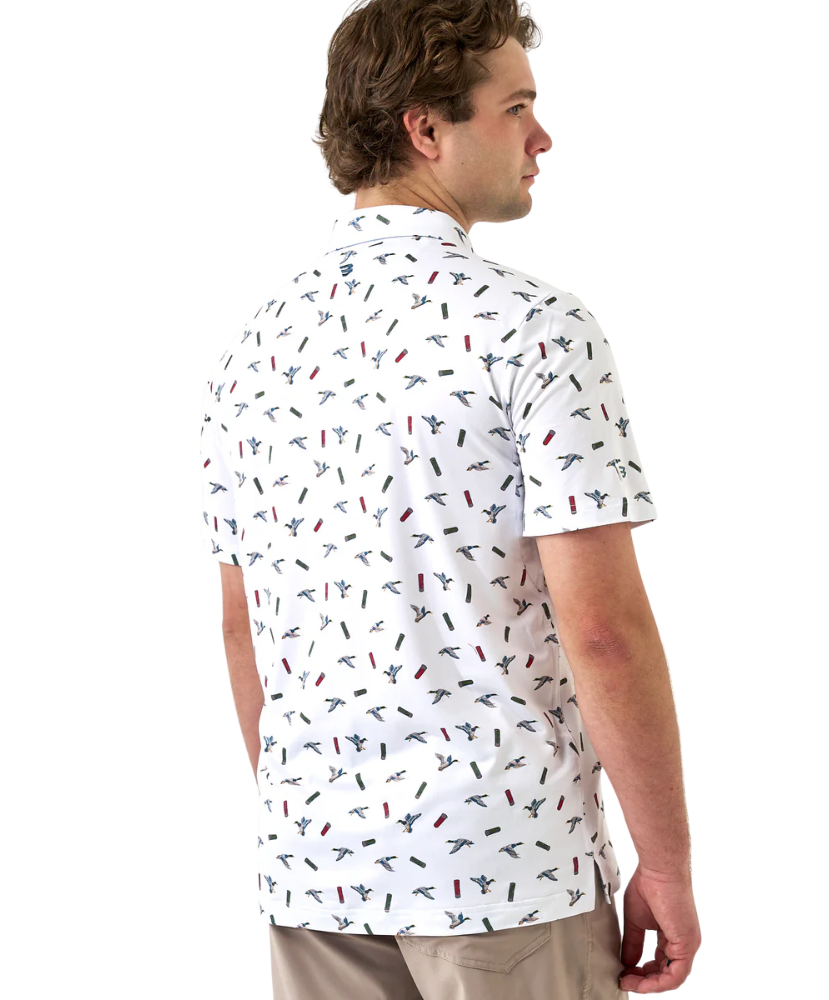 Man wearing a white polo shirt with small colorful ducks and shotgun shells patterns on a white background