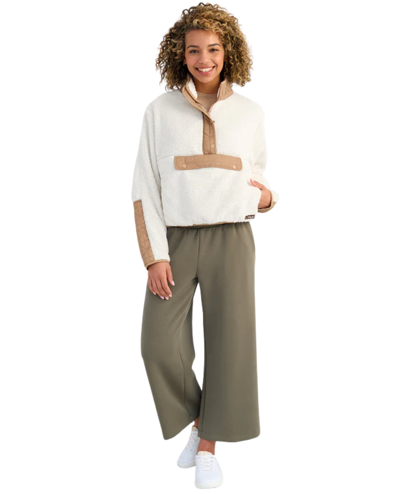 Woman wearing a white and beige fleece pullover on a white background