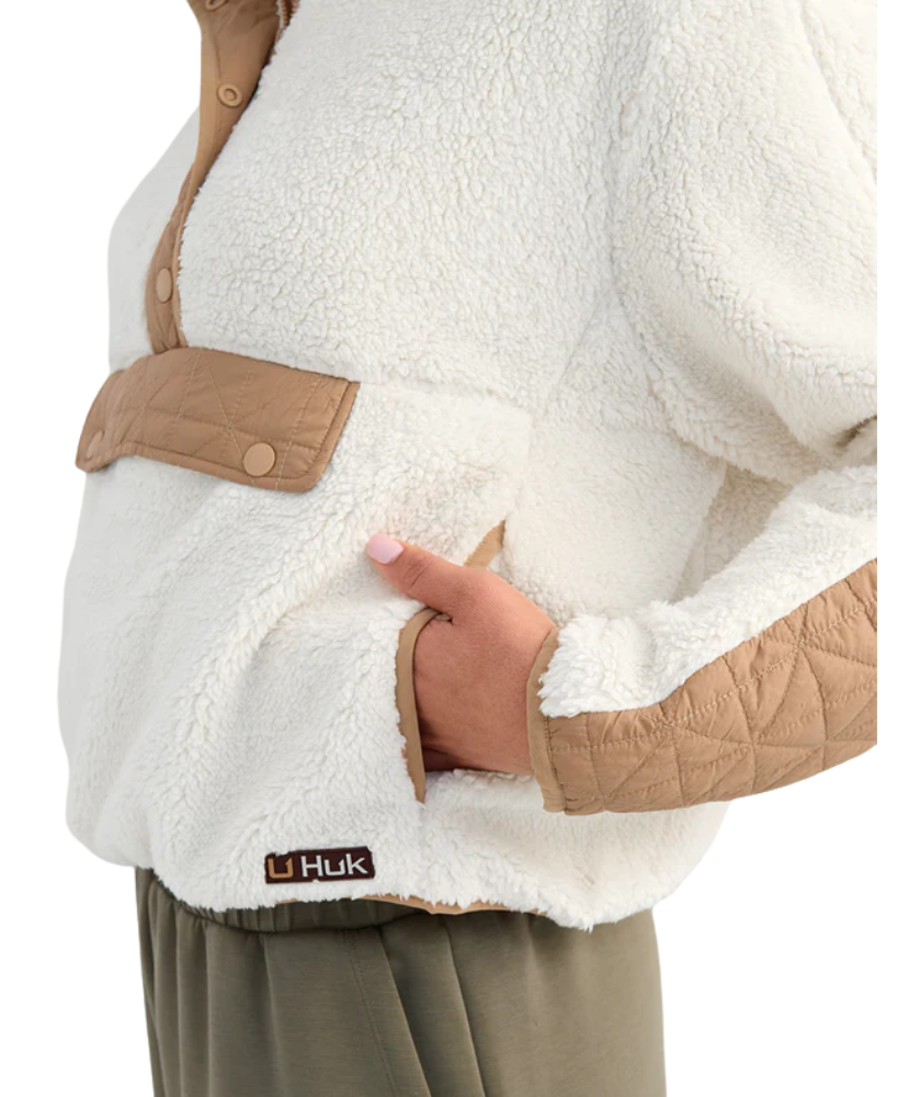 Woman wearing a white and beige fleece pullover on a white background