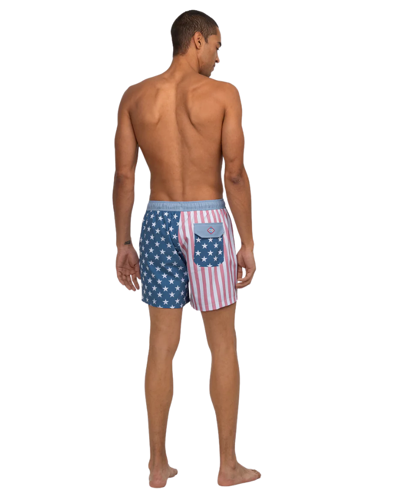 Man wearing American flag patterned swim shorts on a white background