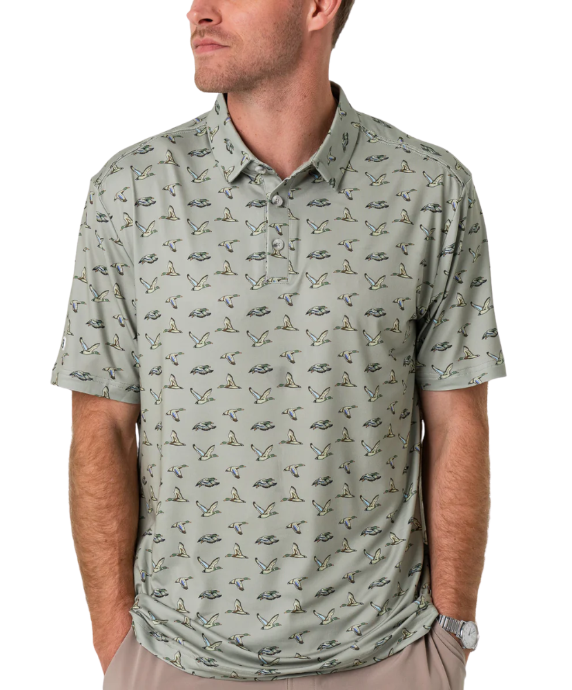 Man wearing a flying duck patterned green polo shirt on a white background