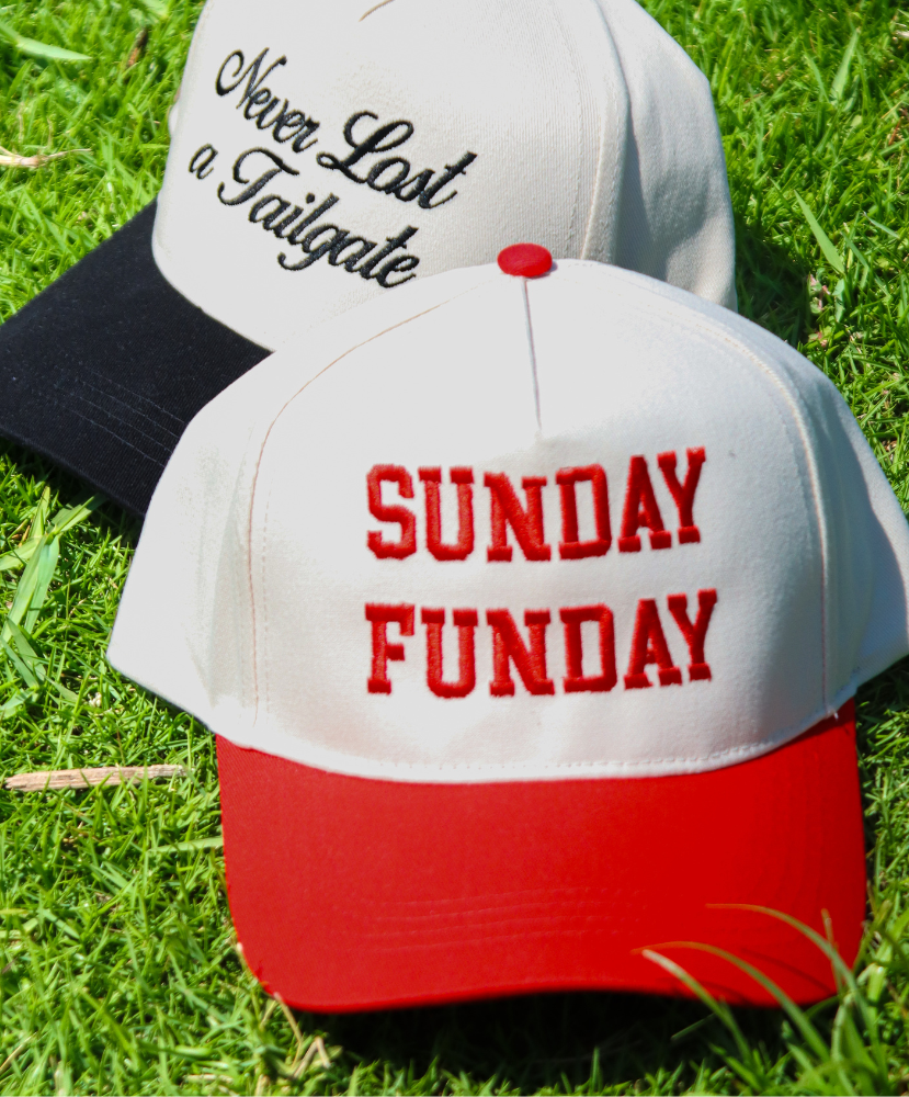Two hats on grass with 'Never Lost a Tailgate' and 'SUNDAY FUNDAY' text.
