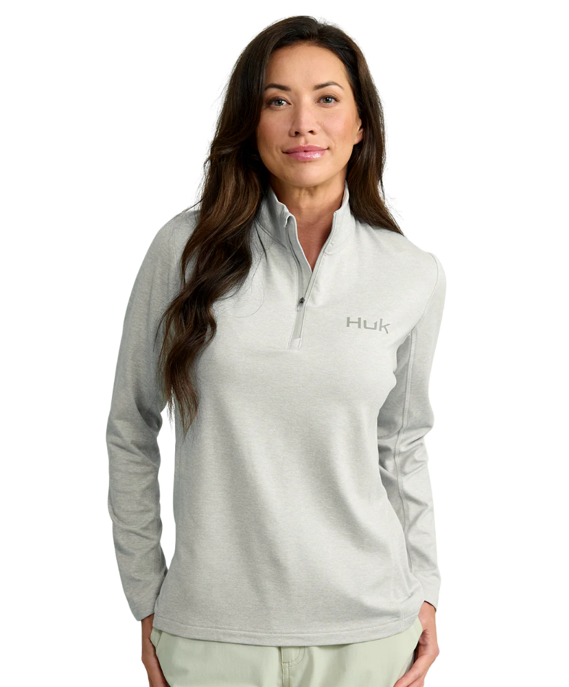 Woman wearing a gray Huk pullover on a white background